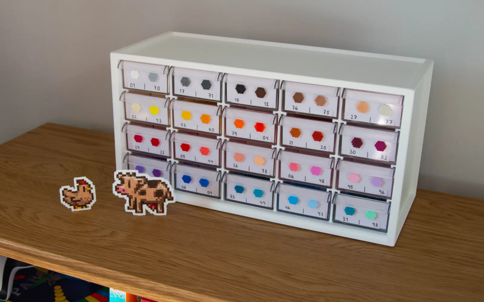 Opbevaringskasse med perler samt to perleplader af en høne og en ko